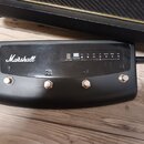 Černý nožní spínací pedalboard značky Marshall. Obsahuje čtyři kovové spínače označené číslicemi 1 až 4 a displej s nápisy MG, Programcontroller Foot…