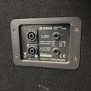 Fotografie zachicuje zadní panel černého subwooferu s nápisy YAMAHA SUBWOOFER MODEL AX15W. Panel obsahuje dva kombinované konektory (XLR/jack) a jede…