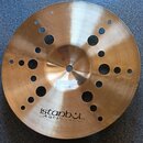 Zlatavý kovový činel s několika otvory různých velikostí rozmístěnými po celém povrchu. V dolní části je čitelné logo istanbul Agop a nápis Made in T…