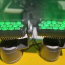 Dvě černé LED par světla s kovovým chladičem v dolní části. Každý reflektor obsahuje 12 zeleně svítících LED diod za průhledným krytem. Světla jsou u…