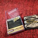Sada tří snímačů pro elektrickou kytaru v krémové barvě, umístěná na černém podložkovém materiálu. Na snímačích jsou viditelné nápisy ALNICO II BLUES…