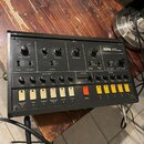 Černý kytarový syntetizér s nápisem KORG GUITAR SYNTHESIZER. Přední panel obsahuje množství otočných potenciometrů, přepínačů a řadu žlutých tlačítek…