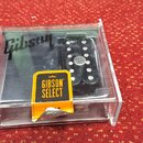 V průhledném plastovém boxu se nachází černý elektrický kytarový snímač. Na povrchu je vidět bílé logo Gibson a žlutá nálepka s nápisem GIBSON SELECT…
