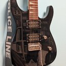 Černá elektrická kytara s hnědým hnedým hmatníkem a dvěma humbuckery. Na kytaru je nasazený šedý popruh s bílým nápisem POLICE LINE DO. Nástroj má st…