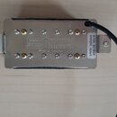 Kytarový snímač s kovovým krytem stříbrné barvy a zlatými ladicími šroubky. Na krytu je vyražen nápis Seymour Duncan a Made in America. Na boku je př…