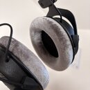 Černé sluchátka s šedými velurovými náušníky. Na horním plastovém článku je nápis MADE IN CHINA a symbol CE. Povrch nástrojů vykazuje mírné známky po…