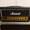 Kytarový zesilovač značky Marshall, model JCM 800 LEAD SERIES STUDIO. Má černý texturovaný povrch, bílý lem kolem mřížky a zlatý ovládací panel s kno…
