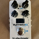 Bílý kytarový efekt s nápisy PLETHORAX1 a TONEPRINT LOADER. Na spodní části je logo tc electronic a nápis TRUE BYPASS. Zařízení má čtyři černé otočné…