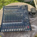 Tmavě modrý mixážní pult značky YAMAHA, model MG166CX. Zařízení obsahuje numerous vstupní kanály s posuvníky a otočnými knoflíky v zelené, červené a…