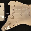 Bílá plastová pickguard pro elektrickou kytaru s třemi sloty na snímače a dvěmi potenciometry s nápisy VOLUME a TONE. Součástí je bílá plastová krytk…