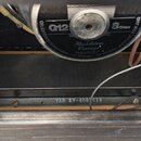 Fotografie zachycuje vnitřek reproduktorové skříně. V horní části je vidět zadní strana reproduktoru s nápisy G12, Celestion International Ltd. Foxha…