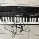 Černý digitální klavír značky YAMAHA s modelem PsX-600. Nástroj má standardní klávesnici s bílými a černými klávesami a horní panel s množtstvem tlač…