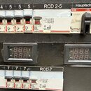 Fotografie zobrazuje elektrický rozvaděč s řadou jističů a dvou digitálních měřičů napětí a proudu. Jsou zde viditelné značky Legrand a ABB, konkrétn…