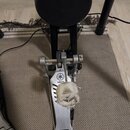 Kovový basový pedál s logem YAMAHA a doprovodným symbolem třívětvného vidličky. Na pedálu je upevněn bílý, výrazně opotřebovaný a roztrhaný plstěný b…