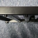 Černý kovový pedalboard s nastavitelnými nožkami. Na pravé straně je bílý nápis „Palmer pedalbay 40“ doplněný o grafický symbol hor. Povrch je hladký…