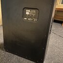 Zadní strana černé kytarové reprobedny s povrchem z textilu a kovovými rohy. Na zadním panelu je štítek s nápisy ENGL E 212 PRO Speaker Cabinet, MONO…
