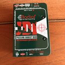 Zelená pasivní DI box s bílým předním panelem. Na panelu je červeně a černě napsáno logo Radial engineering a model JDI, dále nápisy PASSIVE DIRECT B…
