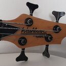 Hlava basové kytary z přírodního dřeva s černými ladicími kolíky. Na dřevěné části je čitelné logo Washburn a pod ním nápis HAMMER. Hrabednice je vyr…