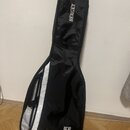 Černý softcase na hudební nástroj s bílým pruhem podél zipu. Na horní části je bílý nápis HERGET a v dolní části se nachází logo ve tvaru štítu s pís…