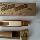 Kartonová krabička s nápisy NEW "Super" TONE MASTER OTTO KING BELL METAL, 2201 Industrial Parkway Elkhart, IN 46516 a SAXOPHONE MOUTHPIECE. Vedle kra…