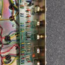 Fotografie zachycuje vnitřek elektronického zařízení s viditelnou základní deskou plnou součástek, jako jsou rezistory a kondenzátory. Na desce jsou…