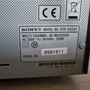 Detail štítku na zadní straně stříbrného přístroje. Je zde uveden nápis SONY® MODEL NO. STR-DG520 MULTI CHANNEL AV RECEIVER AC 230V ~ 50/60Hz 220W. N…
