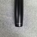Detail spodní části černého mikrofonu s matným povrchem. Na spodku je bílý nápis KSM9HS a pod ním symboly kruhu a sluchátek. Povrch je v dobrém stavu…