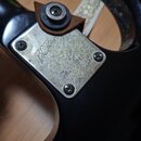 Detail kovového šiltíku na černé kytáře. Na šiltíku je vyryto logo B.C Rich a sériové číslo N01070132. Povrch kovu vykazuje známky opotřebení a zneči…