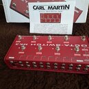 Červený kytarový spínací pedalboard s nápisem OCTA-SWITCH MK3. Zařízení má osm stoupacích spínačů, několik posuvných přepínačů a konektory pro vstup…