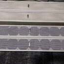Čtyři bílé mřížky reproduktorů v obdélníkovém tvaru. Dvě horní mají plný povrch s malými otvory a nápisem FBT, dvě spodní mají perforovaný povrch s k…
