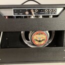 Zadní strana kytarového komba v černé textuře. V horní části je ovládací panel s nápisy ANODE FUSE T0.5A/250V, MAINS FUSE T1A/250V, SPEAKERS EXTERNAL…