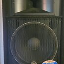 Černý reproduktor s kovovou ochrannou mřížkou. V horní části je nápis Extra Band a v dolní části logo YAMAHA. Na mřížce je nalepený štítek s textem S…