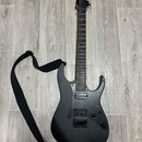 Černá elektrická kytara s matným povrchem a černým hmatníkem. Nástroj má dva humbuckery, fixační most a černý popruh. Na kytáře nejsou viditelné žádn…