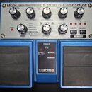 Modrý kytarový efekt s kovovým ovládacím panelem. V horní části je nápis CE-20 DIMENSIONAL PROCESSOR CHORUS ENSEMBLE a v dolní části logo BOSS. Panel…