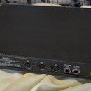 Černý rackový procesor s kovovým šasi. Na zadním panelu jsou viditelné nápisy LEXICON, INC. MADE IN U.S.A., PCM 70 a napájecí údaje 50/60 Hz, 25W. Za…
