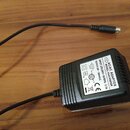 Černý síťový adaptér s napájecím kabelem a konektorem. Na bílém štítku je uveden nápis AC/AC ADAPTOR, MODEL: HA41N9606R, INPUT: 230-240V~ 50/60Hz 0.1…