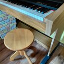 Digitální piano v dřevěném provedení s černou klaviaturní lištou. Na černé části nad klávesami je zlatý nápis „Bohemia RSP 10“. K nástroji patří jedn…