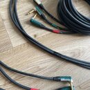 Tři kábely s 6,3mm jack konektory v různých barvách (stříbrná, zelená). Na černém plášti kabelů je bílý nápis: Cordes GERMANY GUITAR CGK ROAD 75 1x0.…