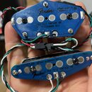 Dvě modré plastové krytky snímačů elektrické kytary s připojeným elektroinstalacemi. Na horním krytu je bílý nápis Fender a text ULTRA TELE VINTAGE B…