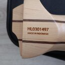 Detail dřevěného nástroje světlé barvy s dvěma tmavými vodorovnými pruhy. Na povrchu je vyryt nápis HL0301497 a pod ním MADE IN INDONESIA. Povrch je…