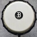 Bílá bubenová membrána s černým logem ve tvaru stylizedovaného písmene B a nápisem MEINL. Okraj nástroje je opleten černým šňůrkem. Povrch membrány v…