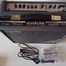 Šedý kytarový kombo zesilovač s černou mřížkou a koženou rukojetí. Na horním ovládacím panelu je nápis SILVERLINE a značka Blackstar. Před přístrojem…