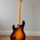 Zadní strana elektrické basové kytary s tělem v provedení sunburst (černá, červená a žlutá). Kytara má světlý dřevěný krk a hmatník. Na zadní straně…