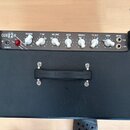 Černý kytarový kombo zesilovač s koženým povrchem a ovládacím panelem nahoře. Na panelu je nápis CUB 12 R a ovládací prvky s popisky REVERB, TONE, VO…