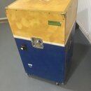Modrý transportní case na kolečkách s horní částí v žlutém provedení. Na boku je nalepený zelený štítek s nápisem VYBRAT CLO. Case má kovové hrany, z…