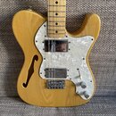 Světle hnědá semiakustická elektrická kytara s přírodním povrchem a bílým perleťovým pickguardem. Na kytaru jsou instalovány dva humbuckery, přičemž…