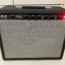Černý kytarový kombo zesilovač s šedou tkanou mřížkou reproduktoru. Na ovládacím panelu jsou nápisy FET, NORMAL, VOLUME, BRIGHT DEEP ROCK JAZZ, TREBL…