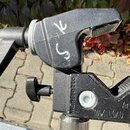 Černý držák na mikrofon s nastavitelní ramenem. Na těle je vyryto značka Manfrotto a nápisy Art.035 a MAX LOAD = 15Kg. Povrch plastu vykazuje známky…