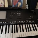 Černý digitální klavír s bílými a černými klávesami. Na panelu jsou viditelná loga YAMAHA a nápis Genos DIGITAL WORKSTATION. Nástroj obsahuje displej…