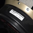 Detail reproduktoru s černým rámem a zlatavým magnetem. Na bílé nálepce je uveden nápis CELESTION, DL18, MADE IN UK a kód T56700087 T5670B 15ohm. Na…